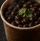 A cup of seasoned slow-simmered black beans.