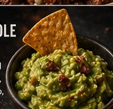A bowl of fresh chunky guacamole flecked with cilantro and onion, lime wedge on the side.