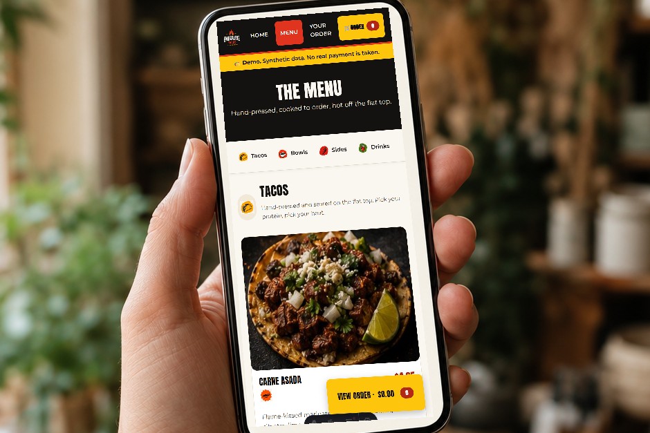 A phone showing the Emberline Tacos ordering menu, held in a hand.